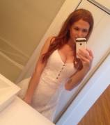 Buxom redhead in a white dress