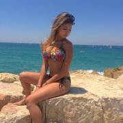 Pretty Girl in Bikini Sits on a Rock