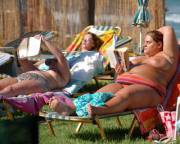 Large topless BBW reading at the beach