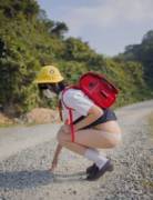 Cute masked school girl flashing outdoors