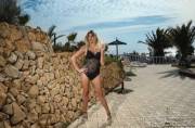 Angelina Torres outside in heals and a body suit