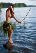 Girl in a grass skirt fishing.