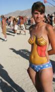 Cute girl with body paint enjoying the burning man festival