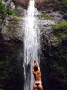 Raising hands up in waterfall