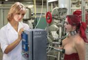 [photo edit] Collared hucow in a factory is automilked by a female attendant