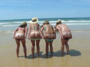 Four girls wearing fashionable hats while mooning