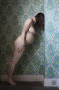 Leaning against the wall.