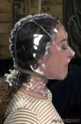 Shiny transparent PVC hood pulled tight around her face