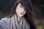 One eye hidden by her brunette hair